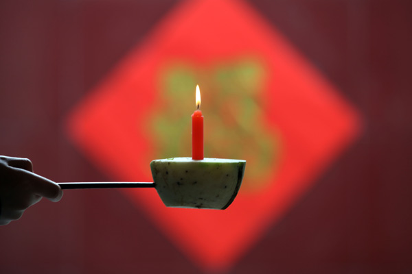 Un homme tient une lampe qu'il a confectionnée pour la Fête des Lanternes, qui tombe le 24 février, à Anyang, dans la Province du Henan, le 20 février 2013. [Photo Chang Zhongzheng / Asianewsphoto]
