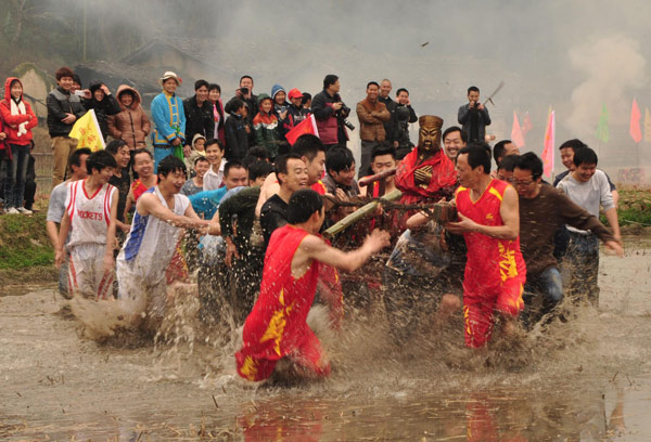 Des villageois transportant la statue de Guan Gong (Lord Guan) courent dans un champ lors d'une activité destinée à accueillir la Fête des Lanternes, qui tombe le 24 février, dans le village de Julin, dans le Comté de Changting, dans la Province du Fujian, dans l'Est de la Chine, le 21 février 2013. [Photo / Xinhua]