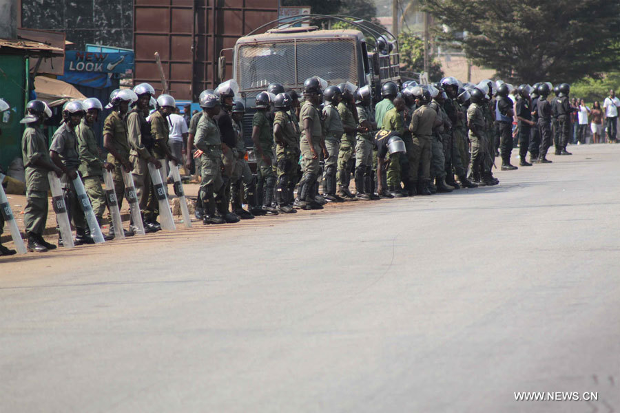La police bloque une rue au début d'une manifestation organisée par l'opposition, à Conakry, capitale de la Guinée, le 28 février 2013. Des forces de sécurité étaient déployées au siège du parti du président guinéen Alpha Condé, afin de le protéger contre les manifestants demandant la tenue d'élections législatives libres en mai 2013.