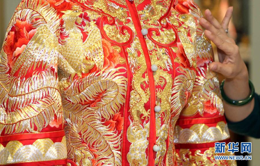 Une photo prise le 2 mars 2013 montrant une robe de mariée dessinée par Guo Pei présentée au magasin amiral « Chinese Bride » (« jeune mariée chinoise ») au n ° 22 Waitan à Shanghai, dans l'Est de la Chine. Un défilé de robes de mariages a été organisé par Guo Pei, la propriétaire du magasin amiral de « Chinese Bride» et aussi styliste de premier plan, qui a créé des robes de cérémonie à la fois pour le Gala de la Fête du Printemps de CCTV et les Jeux Olympiques de Beijing en 2008. [Photo / Xinhua]