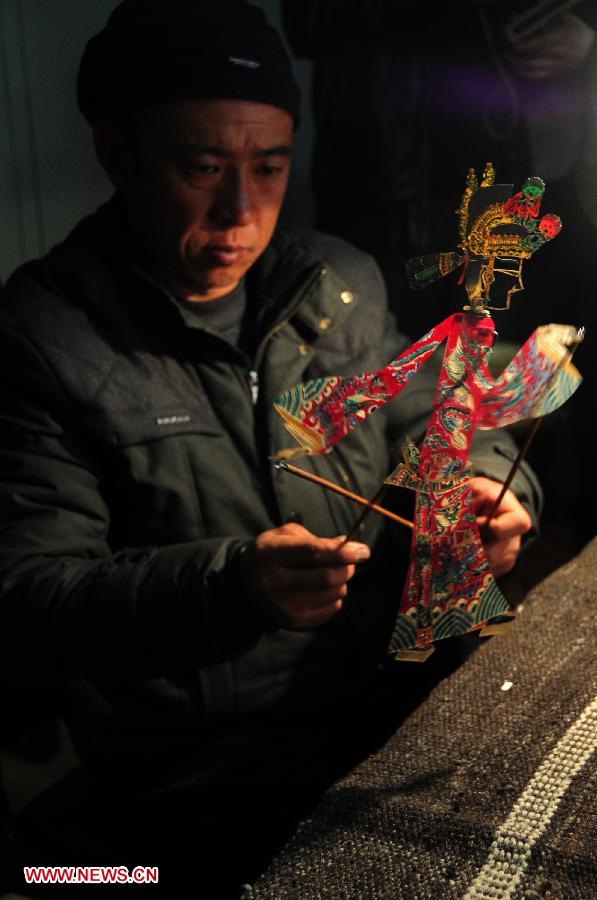 Le 4 mars 2013, un artistenous fait découvrir l'un des personnages d'une pièce du théâtre d'ombres présentée dans le district de Xuanxian de la province chinoise du Gansu. (Xinhua/Fan Peishen)