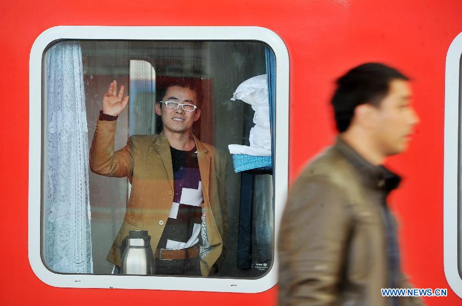 Un homme fait un geste d'au revoir à ses amis depuis un train, à Yinchuan, capitale de la région autonome Hui du Ningxia (nord-ouest), le 6 mars 2013.