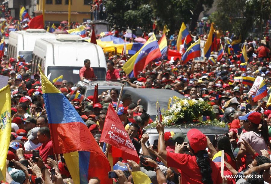 Le 6 mars 2013 dans les rues de Caracas, capitale vénézuélienne, des habitants accompagnent le cortège funéraire de leur défunt président Hugo Chavez. (Xinhua/AVN)