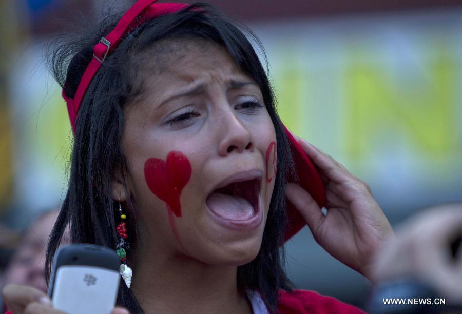 Une femme émue participe au cortège funèbre de “son” défunt président Hugo Chavez, le 6 mars 2013 à Caracas. (Xinhua/AVN)