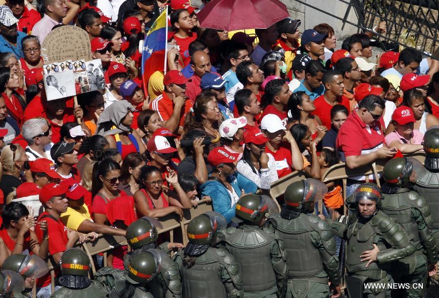 Le 6 mars 2013 à Caracas, capitale vénézuélienne, des membres de la Garde nationale vénézuélienne forment une barrière de sécurité pour contenir la foule des deux côtés du cortège funéraire de leur défunt président Hugo Chvez. (Xinhua/Juan Carlos Hernandez)