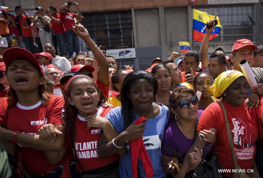 Le 6 mars 2013 dans les rues de Caracas, capitale vénézuélienne, des habitants accompagnent le cortège funéraire de leur défunt président Hugo Chavez. (Xinhua/AVN)