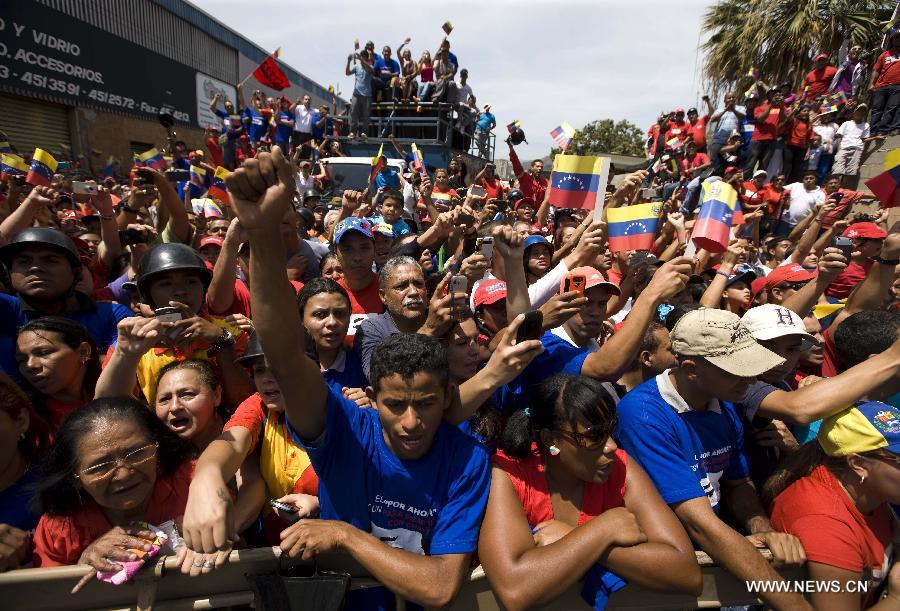 Le 6 mars 2013 dans les rues de Caracas, capitale vénézuélienne, des habitants accompagnent le cortège funéraire de leur défunt président Hugo Chavez. (Xinhua/AVN)