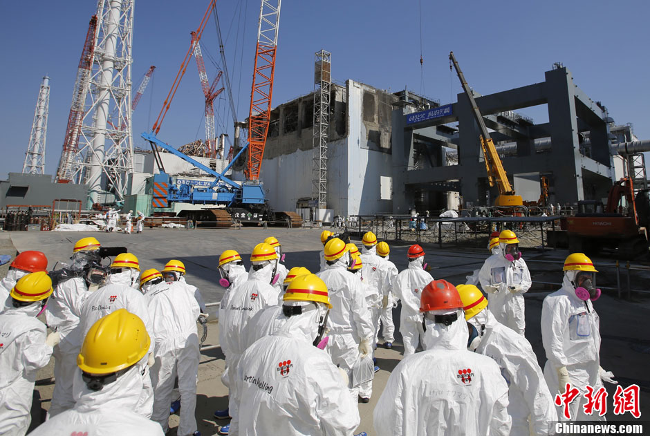 Des journalistes rassemblés devant les installations du réacteur n° 4 de la centrale nucléaire Daiichi de Fukushima.