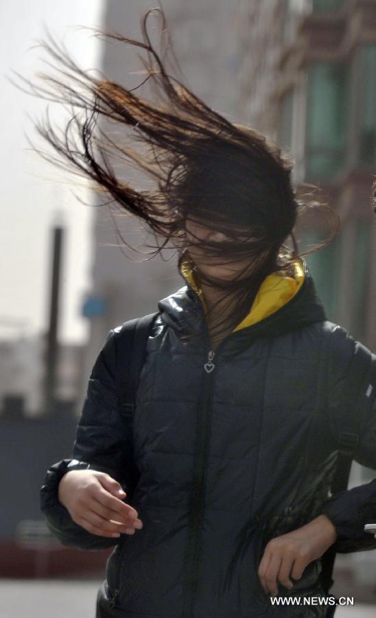 Une femme affronte des rafales de vent à Beijing, la capitale chinoise balayée samedi par une tempête de sable, le 9 mars 2013. (Photo : Li Wen) 