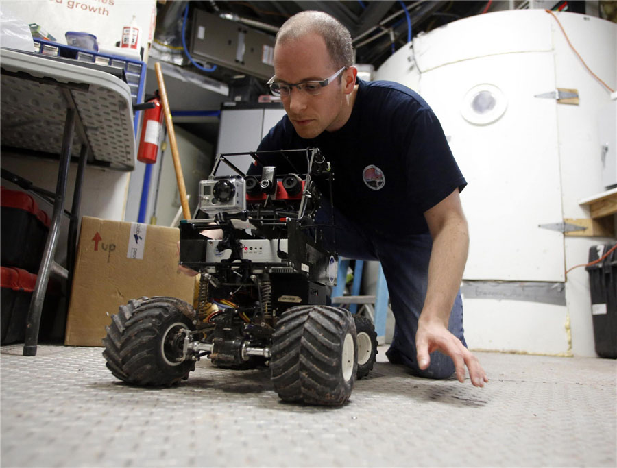 Le 2 mars 2013 à la Station Martienne de Recherche du Désert basée dans le désert de l'Etat d'Utah aux Etats-Unis, Matt Cross, ingénieur de l'Equipe 125 de la mission EuroMoonMars B, travaille sur un robot. [Photo/Agences]