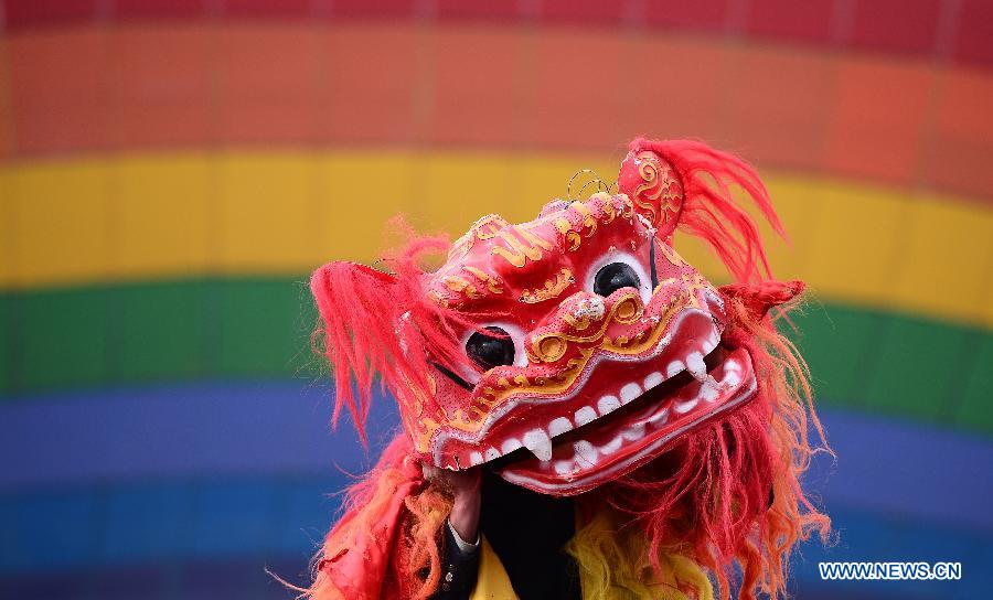 Le 13 mars 2013, dans le district autonome de l'ethnie Tu de Huzhu, dans la province du Qinghai, dans le Nord-ouest de la Chine, des acteurs exécutent une danse du lion pour célébrer le Er Yue Er. (Xinhua/Zhang Hongxiang)