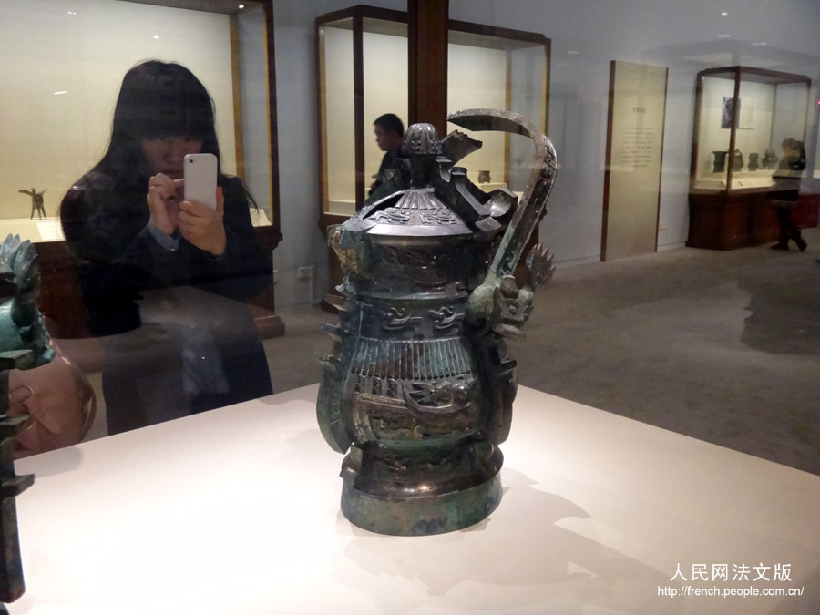 Une visiteuse photographie un objet présent dans l'exposition "Regard sur le pays natal", au Musée national de Chine, à Beijing, le 17 mars 2013.
