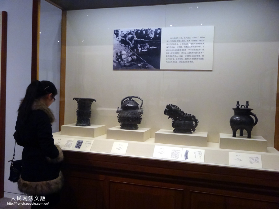 Une visiteuse contemple des objets présents dans l'exposition "Regard sur le pays natal", au Musée national de Chine, à Beijing, le 17 mars 2013.