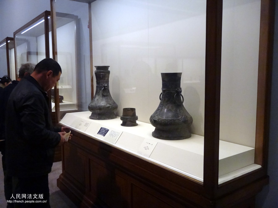 Un visiteur contemple des objets présents dans l'exposition "Regard sur le pays natal", au Musée national de Chine, à Beijing, le 17 mars 2013.