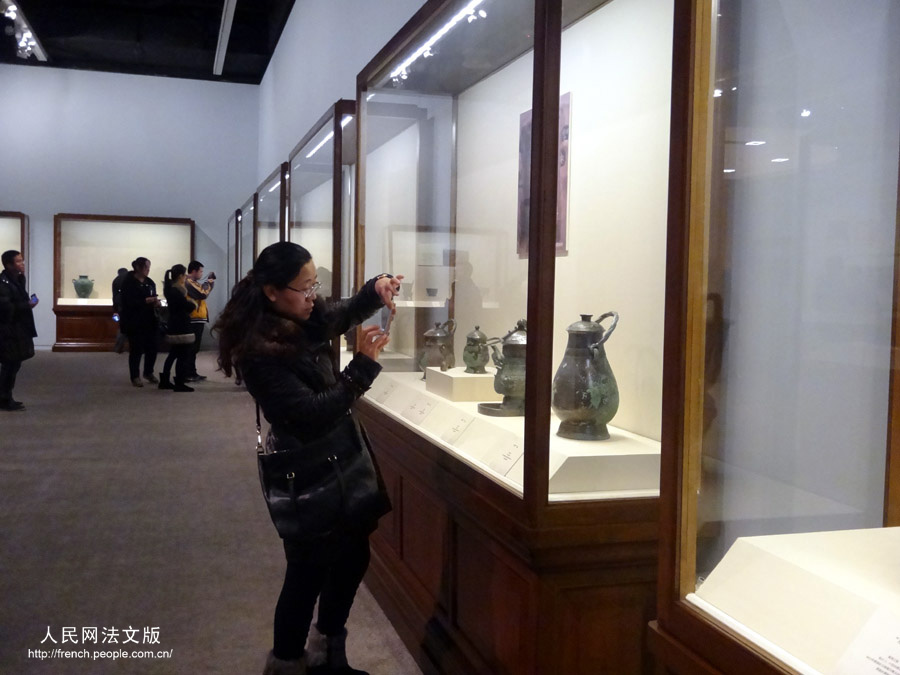 Une visiteuse photographie un objet présent dans l'exposition "Regard sur le pays natal", au Musée national de Chine, à Beijing, le 17 mars 2013.
