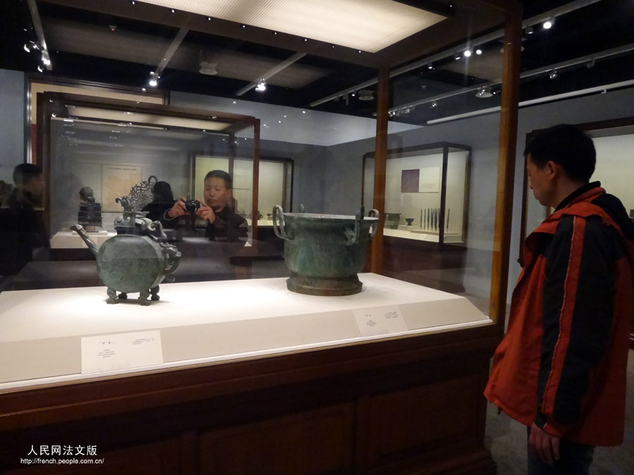 Des visiteurs contemplent des objets présents dans l'exposition "Regard sur le pays natal", au Musée national de Chine, à Beijing, le 17 mars 2013.