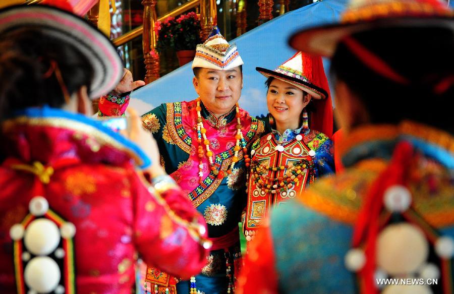 Un couple de jeunes mariés prend la pose, lors d'une cérémonie d'un mariage traditionel de l'ethnie Yugur, organisée le 16 mars 2013, dans le le district autonome Yugur de Sunan de la province du Gansu. (Xinhua/Zhang Meng)