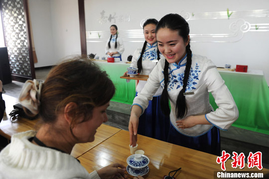 Le 17 mars 2013, les triplées Zhou Shuangxue, Zhou Shuangjie and Zhou Shuangdi présentent aux invités étrangers, une cérémonie du thé chinois, lors du 4e Festival du thé de Chine, qui a débuté le même jour dans le district du Pujiang de la province du Sichuan. (Photo source: Chinanews.com/ Zhang Lang)