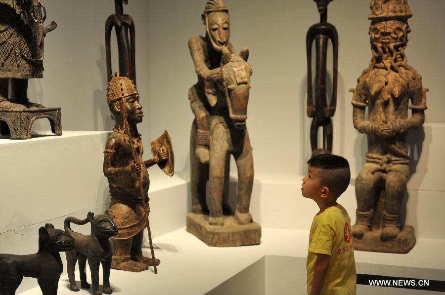 Un jeune garçon regarde des sculptures africaines au Musée national de Chine à Beijing, le 31 mai 2012. Les échanges culturels et entre les peuples entre la Chine et les pays africains se sont développés au cours des dernières décennies, ce qui a renforcé la compréhension mutuelle et l'amitié traditionnelle entre les peuples. Le président chinois Xi Jinping se rendra en visite en Tanzanie, en Afrique du Sud et en République du Congo fin mars et assistera au 5ème Sommet des chefs d'Etat des BRICS les 26 et 27 mars à Durban, en Afrique du Sud. (Photo : Liu Changlong)