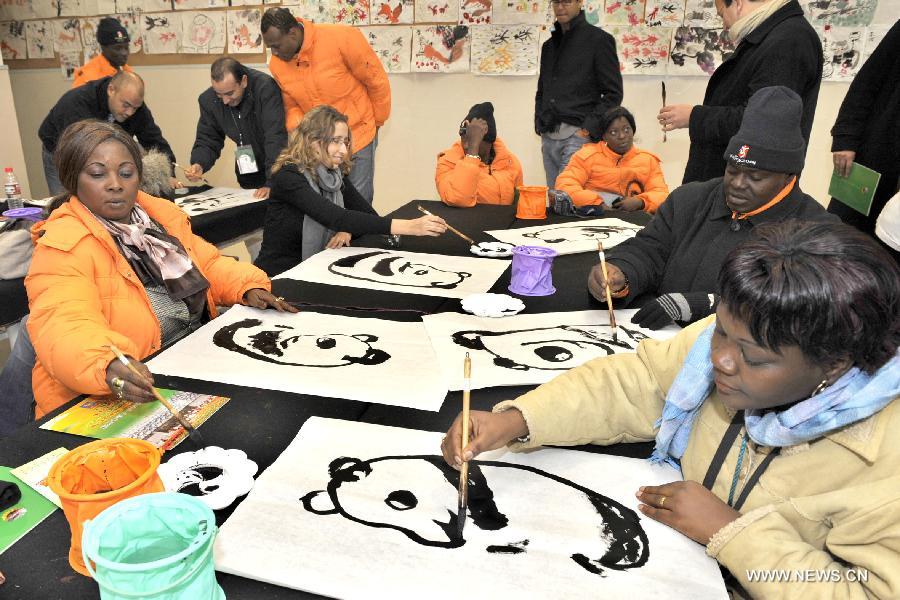 Des Africains apprennent à peindre des pandas avec des pinceaux chinois au Centre de développement de la jeunesse à Hangzhou, capitale de la province du Zhejiang (est), le 4 décembre 2008. Les échanges culturels et entre les peuples entre la Chine et les pays africains se sont développés au cours des dernières décennies, ce qui a renforcé la compréhension mutuelle et l'amitié traditionnelle entre les peuples. Le président chinois Xi Jinping se rendra en visite en Tanzanie, en Afrique du Sud et en République du Congo fin mars et assistera au 5e Sommet des chefs d'Etat des BRICS les 26 et 27 mars à Durban, en Afrique du Sud.