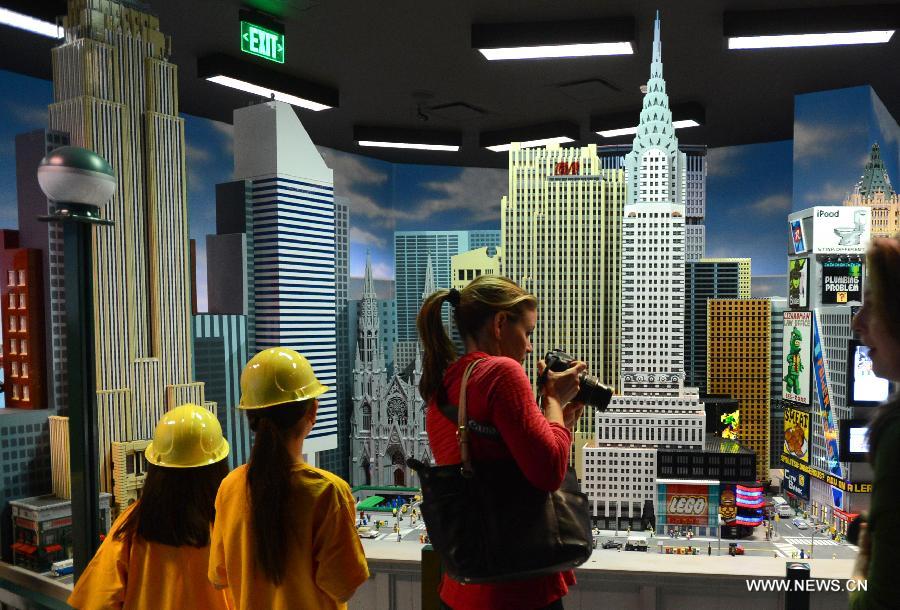 Des visiteurs admirent les modèles réduits des lieux célèbres de Manhattan fabriqués avec près d'un million de briques Lego, au parc Legoland Discovery Center de Westchester, à New York, aux Etats-Unis, le 21 mars 2013. Ce parc flambant neuf ouvrira ses portes le 27 mars. (Photo : Niu Xiaolei)