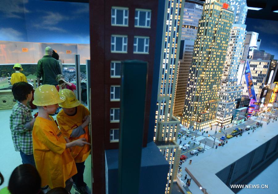 Des visiteurs admirent les modèles réduits des lieux célèbres de Manhattan fabriqués avec près d'un million de briques Lego, au parc Legoland Discovery Center de Westchester, à New York, aux Etats-Unis, le 21 mars 2013. Ce parc flambant neuf ouvrira ses portes le 27 mars. (Photo : Niu Xiaolei)
