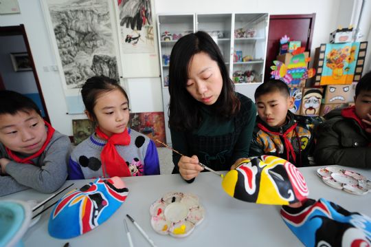 Le 26 mars, une enseignante apprend à ses élèves comment peindre des masques de l'opéra de Beijing, à l'école primaire Xiaoxiang de Yantai.