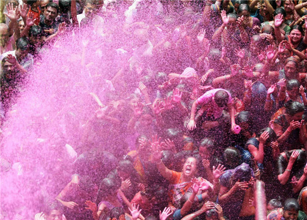 Des gens en joie sous l'eau colorée pulvérisée sur eux lors des célébrations de la fête de Holi, dans la ville d'Ahmedabad, dans l’Ouest de l’Inde, le 27 mars 2013. La Fête de Holi, également connue comme le Festival des Couleurs, annonce le début du printemps et est célébrée dans toute l'Inde. [Photo / Agences]