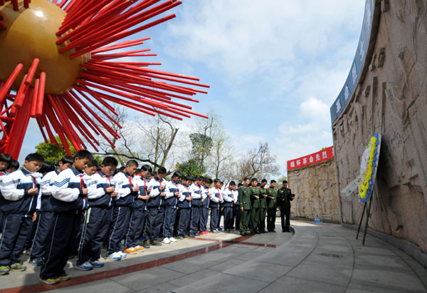 Etudiants et soldats participent à une cérémonie commémorative en l’honneur des martyrs de la Révolution dans la ville de Taizhou, dans la Province du Zhejiang, le 27 mars 2013, à quelques jours de la Fête de Qingming, ou Journée de Balayage des Tombes, qui tombe cette année le 4 avril. Cette journée est une fête nationale lors de laquelle on honore et on se souvient de ses proches défunts dans les cimetières et les monuments commémoratifs. [Photo Jia Ce / Asianewsphoto]