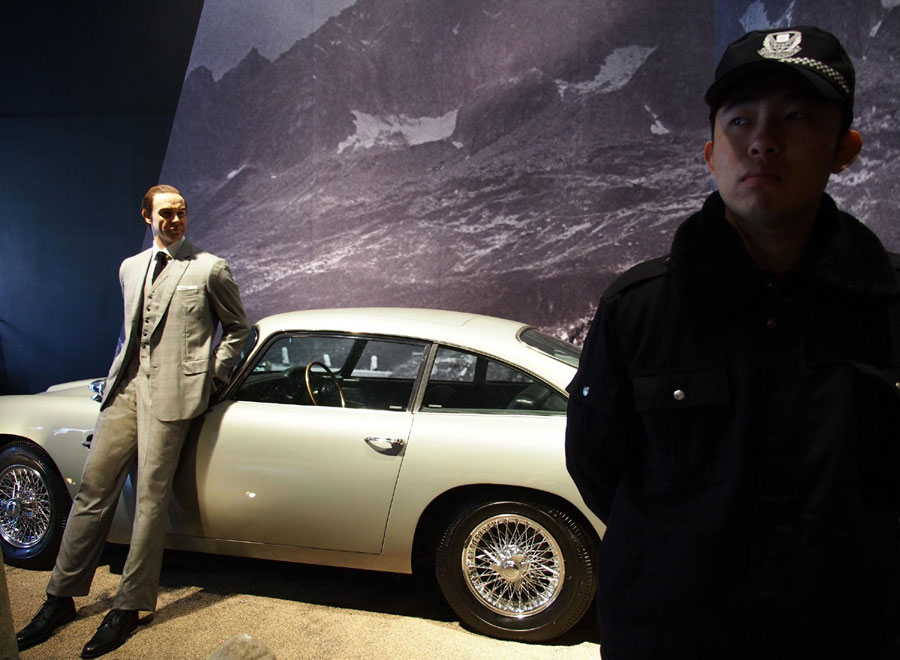 Un agent de sécurité près de la voiture de James Bond lors d'une exposition à Shanghai, le 28 mars 2013. [Photo / Xinhua ]
