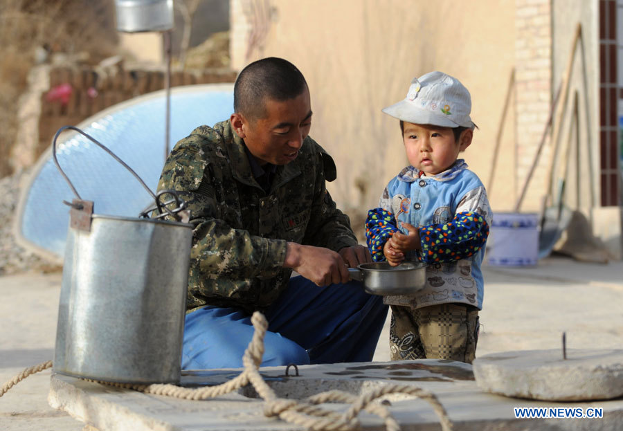 Un villageois nommé Du Weibin lave les mains de son enfant près d'un puits dans le village de Qingshui du district de Lujiagou, de la ville de Dingxi, dans la province chinoise du Gansu (nord-ouest), le 28 mars 2013. Au total, 650.000 habitants manquent d'eau potable dans la province du Gansu en raison de la sécheresse. (Photo : Chen Bin)