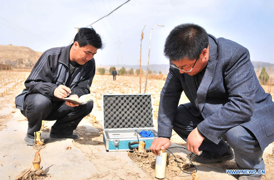 Un scientifique nommé Xing Guo (à droite) contrôle la teneur en eau des sols dans un champs de maïs du village de Qingshui dans le district de Lujiagou, de la ville de Dingxi, dans la province chinoise du Gansu (nord-ouest), le 28 mars 2013. Au total, 650.000 habitants manquent d'eau potable dans la province du Gansu en raison de la sécheresse. (Photo : Chen Bin)