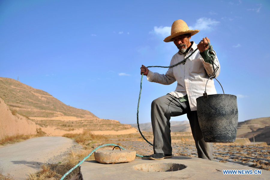 Un villageois nommé He Faquan se procure de l'eau d'un puits presque à sec dans le village de Qingshui du district de Lujiagou, de la ville de Dingxi, dans la province chinoise du Gansu (nord-ouest), le 28 mars 2013. Au total, 650.000 habitants manquent d'eau potable dans la province du Gansu en raison de la sécheresse. (Photo : Chen Bin)