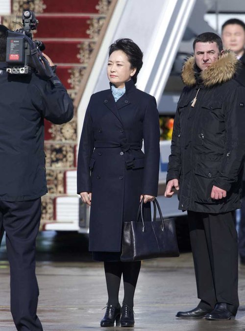Le 22 mars, à l'aéroport de Moscou, portant un sac à main et un manteau cintré bleu marine, la première dame chinoise Peng Liyuan est sortie de l'avion au bras de Xi Jinping.
