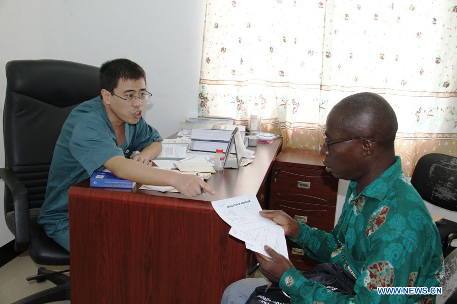 Chang Peng, médecin de l'équipe médicale chinoise, reçoit un patient dans un hôpital construit avec l'aide de la Chine, à Lomé, capitale du Togo, le 28 mars 2013. Le gouvernement chinois envoie des équipes médicales au Togo depuis 1974.