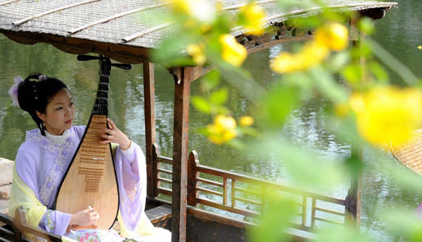 Une actrice présente l'art du Pingtan aux touristes du jardin Liuyan de Suzhou, dans la province du Jiangsu, le 1er avril 2013. [Photo/Xinhua]