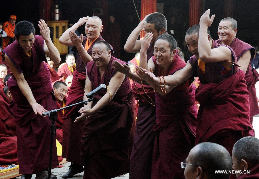 Les moines posent des questions lors de la cérémonie pour défendre les thèses lors du Gexe Lharampa, le plus haut diplôme universitaire pour l'étude du bouddhisme tibétain, au Temple de Jokhang à Lhassa, capitale de la région autonome du Tibet, dans le sud-ouest de la Chine, le 5 avril 2013.