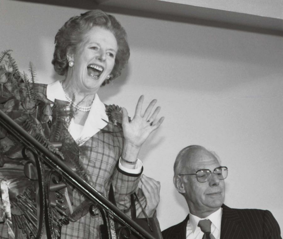 Le Premier ministre britannique Margaret Thatcher adresse un salut souriant depuis l'escalier intérieur du siège du parti conservateur à Londres le 12 juin 1987, après avoir abandonné l'idée d'un retour au pouvoir pour un troisième mandat consécutif après les élections générales.