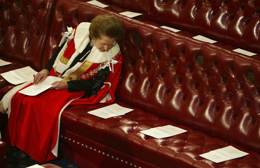 La Baronne Thatcher lit l'ordre du jour, entourée de sièges vides, alors qu'elle attend la Reine Elizabeth II qui doit prononcer son discours lors de la Cérémonie d'ouverture du Parlement à la Chambre des Lords à Londres, le 13 novembre 2002.