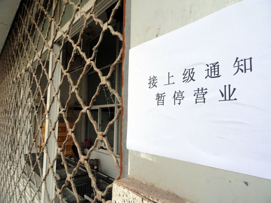 Un panneau expliquant la fermeture affiché à côté du portail d'entrée en fer du marché de la volaille à Suzhou, dans la Province du Jiangsu, dans la Chine de l'Est, le 8 avril 2013. [Photo Wang Jiankang / Asianewsphoto]
