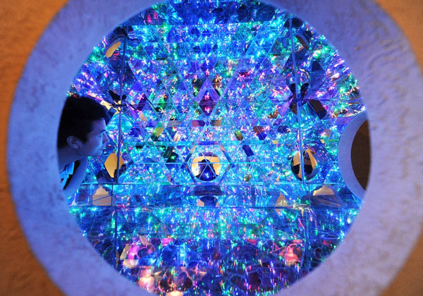 Un employé d’un musée de Shanghai vérifie une « boîte magique » en panneaux de plastique transparent qui reflètent des lumières colorées pour créer une merveille optique éblouissante. [Photo par Lai Xinlin / Pour le China Daily] 