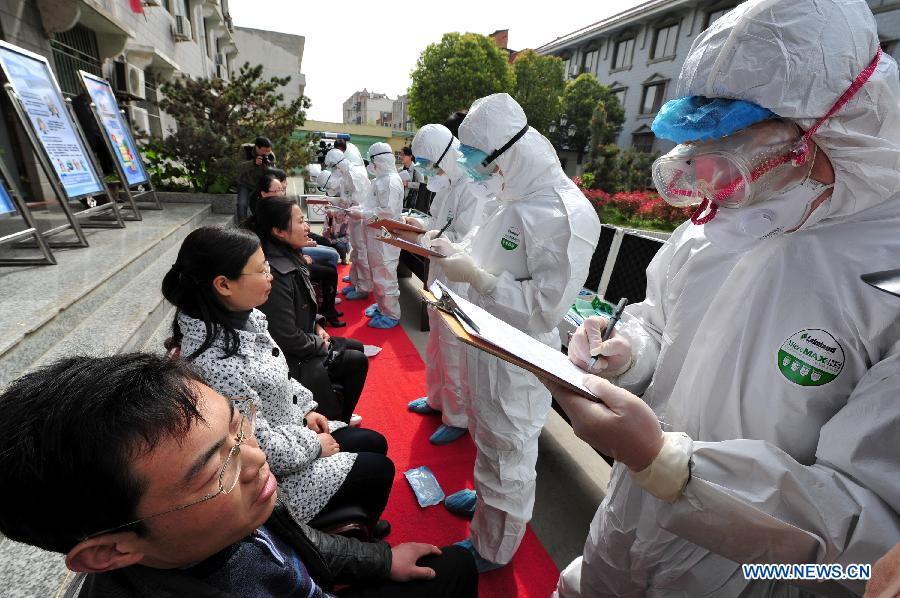 Des travailleurs médicaux vérifient les informations personnelles de "patients" lors d'un exercice d'urgence visant à prévenir la transmission du virus H7N9 à l'homme, dans le district de Changfeng à Hefei, capitale de la province orientale de l'Anhui, le 9 avril 2013.