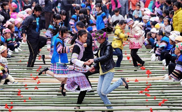 Des touristes jouent avec les habitants locaux lors du festival de la culture et des coutumes folkloriques marquant le « San Yue San » (le troisième jour du troisième mois lunaire du calendrier chinois) dans le Comté de Shizong, dans la Province du Yunnan, dans le Sud-ouest de la Chine, le 12 avril 2013. La Fête du San Yue San, qui attire des dizaines de milliers d’habitants locaux et les touristes venant à la fois de Chine et de l'étranger, a eu lieu ici vendredi. [Photo / Xinhua]