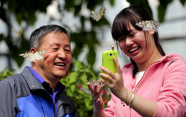 Le 15 avril 2013, des visiteurs jouant avec les papillons du Jardin botanique de Beijing. [Photo/Asianewsphoto]