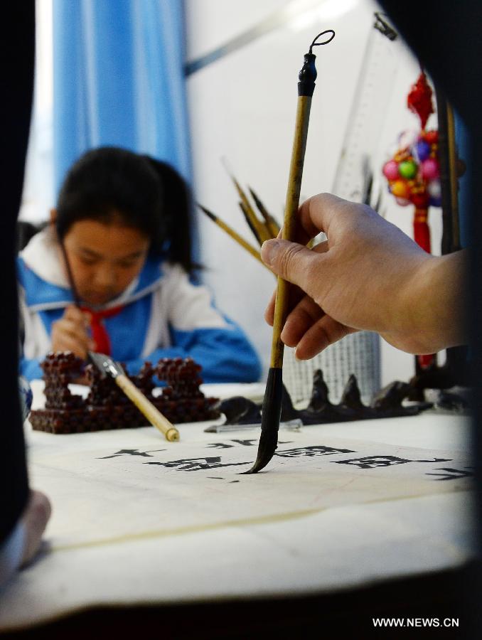 Le 18 avril 2013 au Lycée de l'aéroport No. 94 de Beijing, des élèves assistent à un cours de calligraphie chinoise. (Xinhua/Jin Liangkuai)