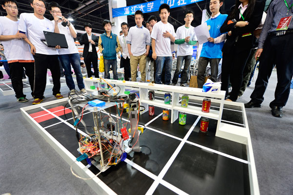 Jeudi, des visiteurs observent un robot, lors d'une foire de l'électronique à Hangzhou,dans la province du Zhejiang. [Photo/Asianewsphoto]