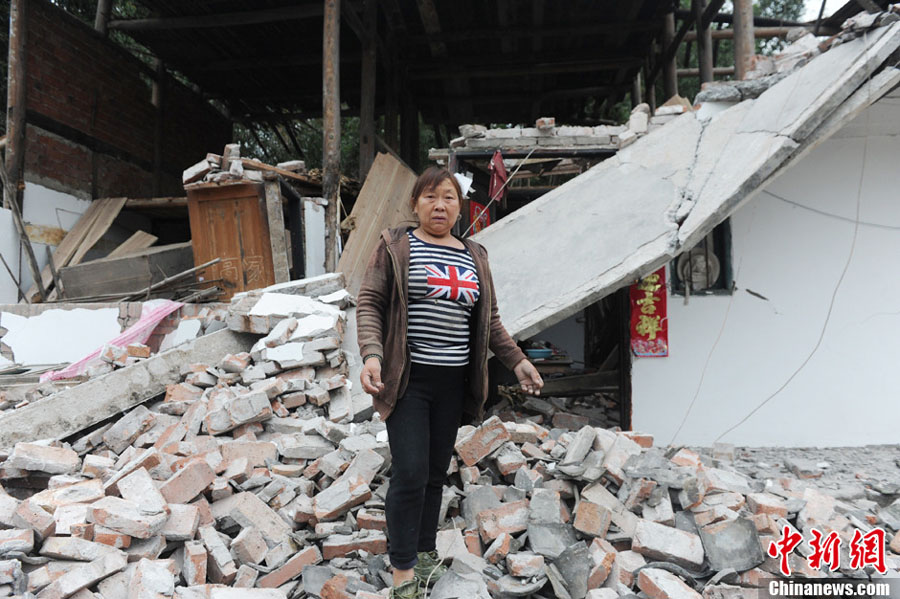Une habitante du bourg Longmen est en larmes devant sa maison dévastée dans un séisme de magnitude 7,0 survenu dans le district de Lushan de la ville de Ya'an, dans la province du Sichuan, le 20 avril 2013. 