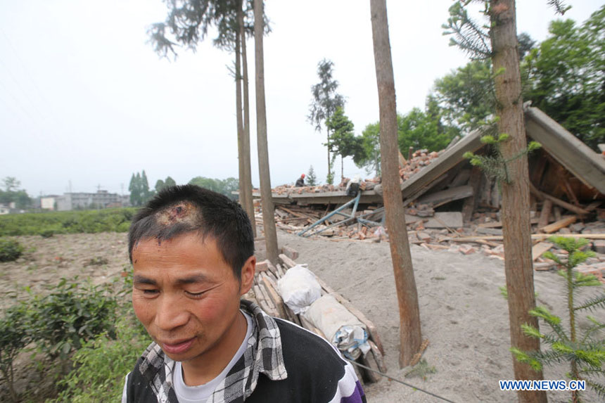 Un habitant du bourg Longquan devant sa maison dévastée dans un séisme de magnitude 7,0 survenu dans le district de Lushan de la ville de Ya'an, dans la province du Sichuan, le 20 avril 2013.