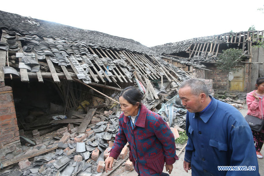 Deux habitants du bourg Longquan devant leur maison dévastée dans un séisme de magnitude 7,0 survenu dans le district de Lushan de la ville de Ya'an, dans la province du Sichuan, le 20 avril 2013.