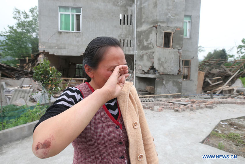 Une habitante du bourg Longquan est en larmes devant sa maison dévastée dans un séisme de magnitude 7,0 survenu dans le district de Lushan de la ville de Ya'an, dans la province du Sichuan, le 20 avril 2013. 